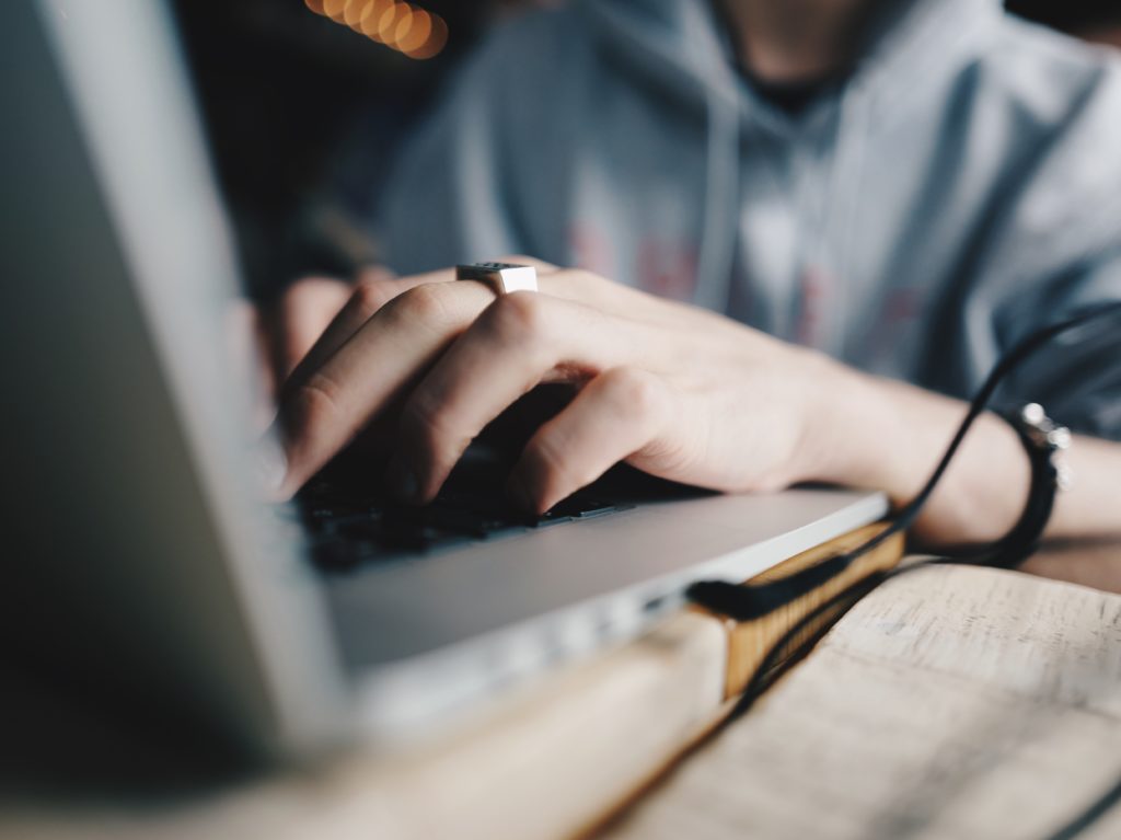 Hands typing a book proposal on a laptop